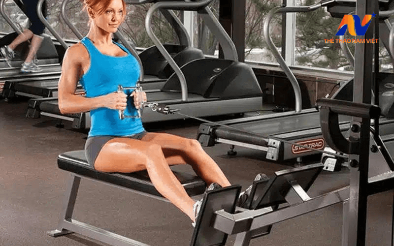 Phụ nữ thực hiện bài tập lưng xô với dây kháng lực để tăng cường sức khỏe