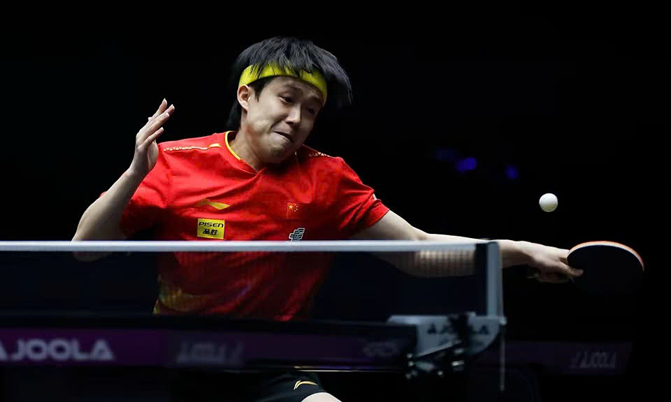 Vận động viên bóng bàn Wang Chuqin thực hiện cú giao bóng mạnh mẽ trong một trận đấu Grand Slam bóng bàn