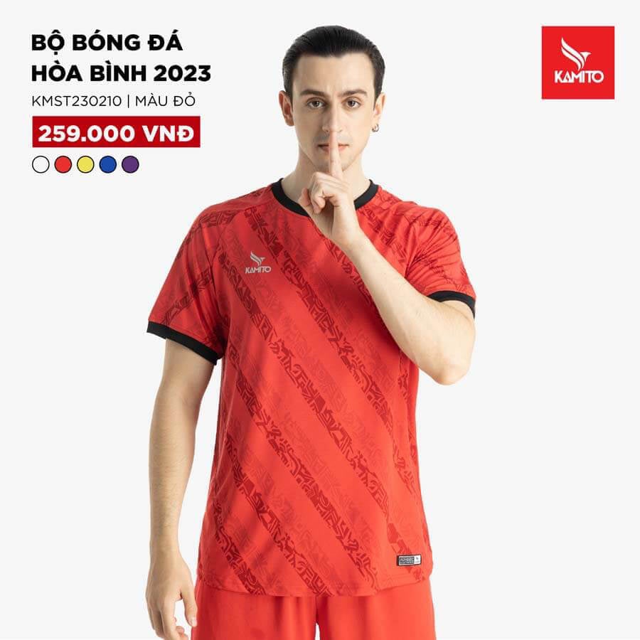 Bộ quần áo bóng đá không logo của câu lạc bộ Hòa Bình, màu đỏ nổi bật trên sân.