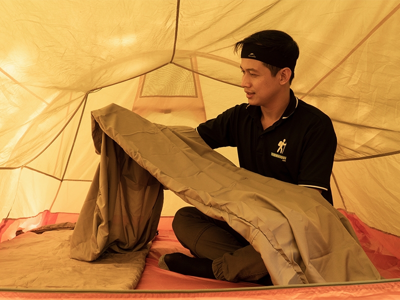 Ảnh chụp một chiếc túi ngủ với không gian cắm trại đẹp mắt, thể hiện tầm quan trọng của việc bảo dưỡng túi ngủ để tận hưởng thiên nhiên
