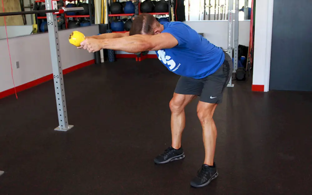 Vận động viên thực hiện bài tập vai Kettlebell Angled Press, đẩy tạ bình vôi theo một góc chéo để tăng cường sức mạnh vai và core.