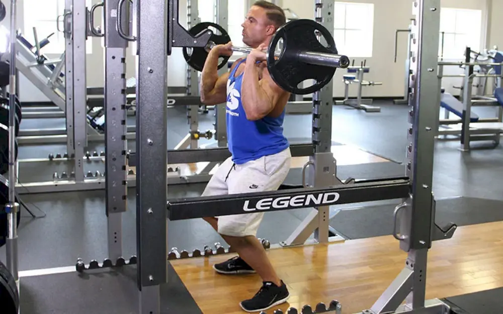 Hình ảnh minh họa bài tập vai Push Press, vận động viên đẩy tạ đòn qua đầu kết hợp lực từ chân để phát triển sức mạnh toàn thân và vai.