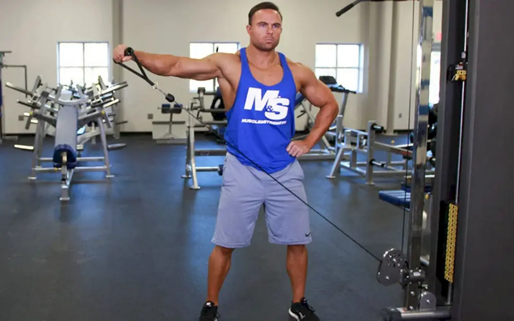 Vận động viên tập vai Single Arm Cable Lateral Raise (Crossbody), nâng cáp ngang vai một tay để ép cơ vai giữa hiệu quả, tăng cường độ rộng và rõ nét cho bờ vai.