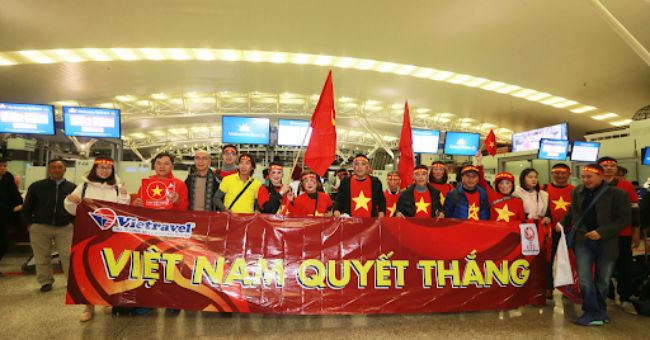 Băng rôn cổ vũ bóng đá của đội tuyển Việt Nam do Vietravel tài trợ, với logo và thông điệp tiếp lửa, thể hiện sự đồng hành từ các đối tác