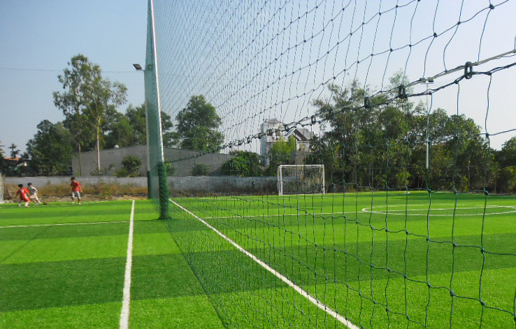 Các cầu thủ đang tập luyện trên sân cỏ nhân tạo tiêu chuẩn FIFA tại sân bóng đá TNT Phú Thọ với không gian thoáng đãng