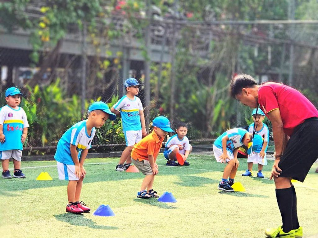 Các em học viên nhí trong trang phục VJSS đang tạo dáng chụp ảnh cùng huấn luyện viên sau buổi tập, thể hiện tinh thần đồng đội