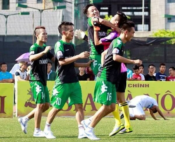 Cảnh một sân bóng đá cỏ nhân tạo với các vạch kẻ rõ ràng, nơi diễn ra các trận đấu phong trào yêu cầu giày chuyên dụng.