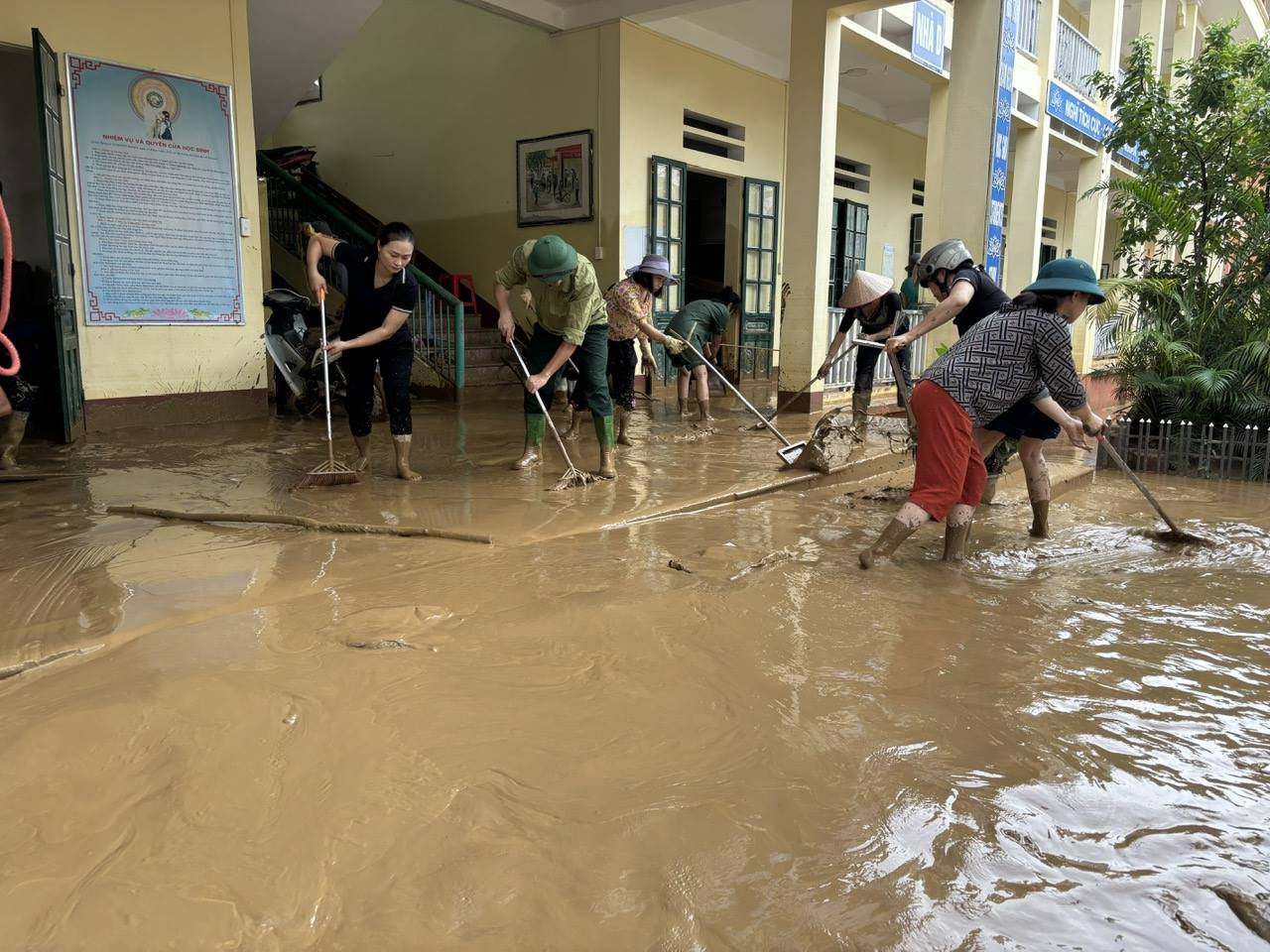 Cảnh trường học khắc phục hậu quả thiên tai, biểu trưng cho tinh thần kiên cường và vượt khó khăn, một phẩm chất quan trọng trong các trận đấu kịch tính của lịch thi đấu bóng chuyền nữ VTV Cup 2023