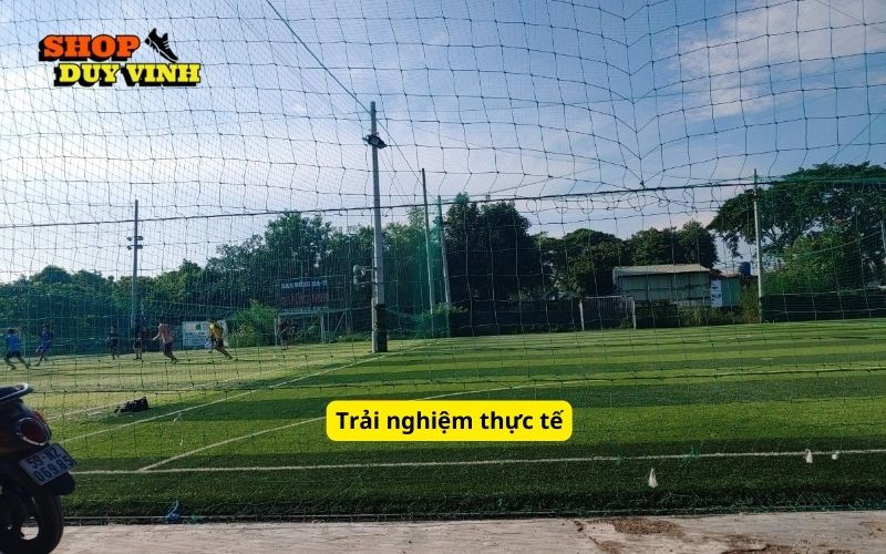 Cầu thủ đang thi đấu trên sân bóng đá Quốc Hưng, thể hiện trải nghiệm chơi bóng thực tế và sống động