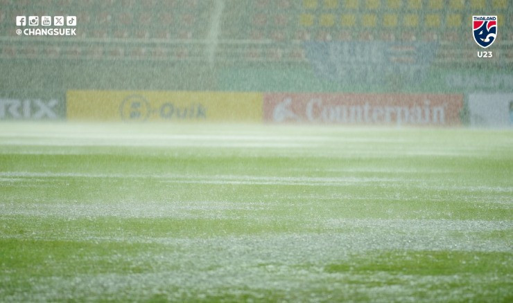 Cầu thủ U23 Malaysia thi đấu trên mặt sân ngập nước trong trận đấu với U23 Thái Lan