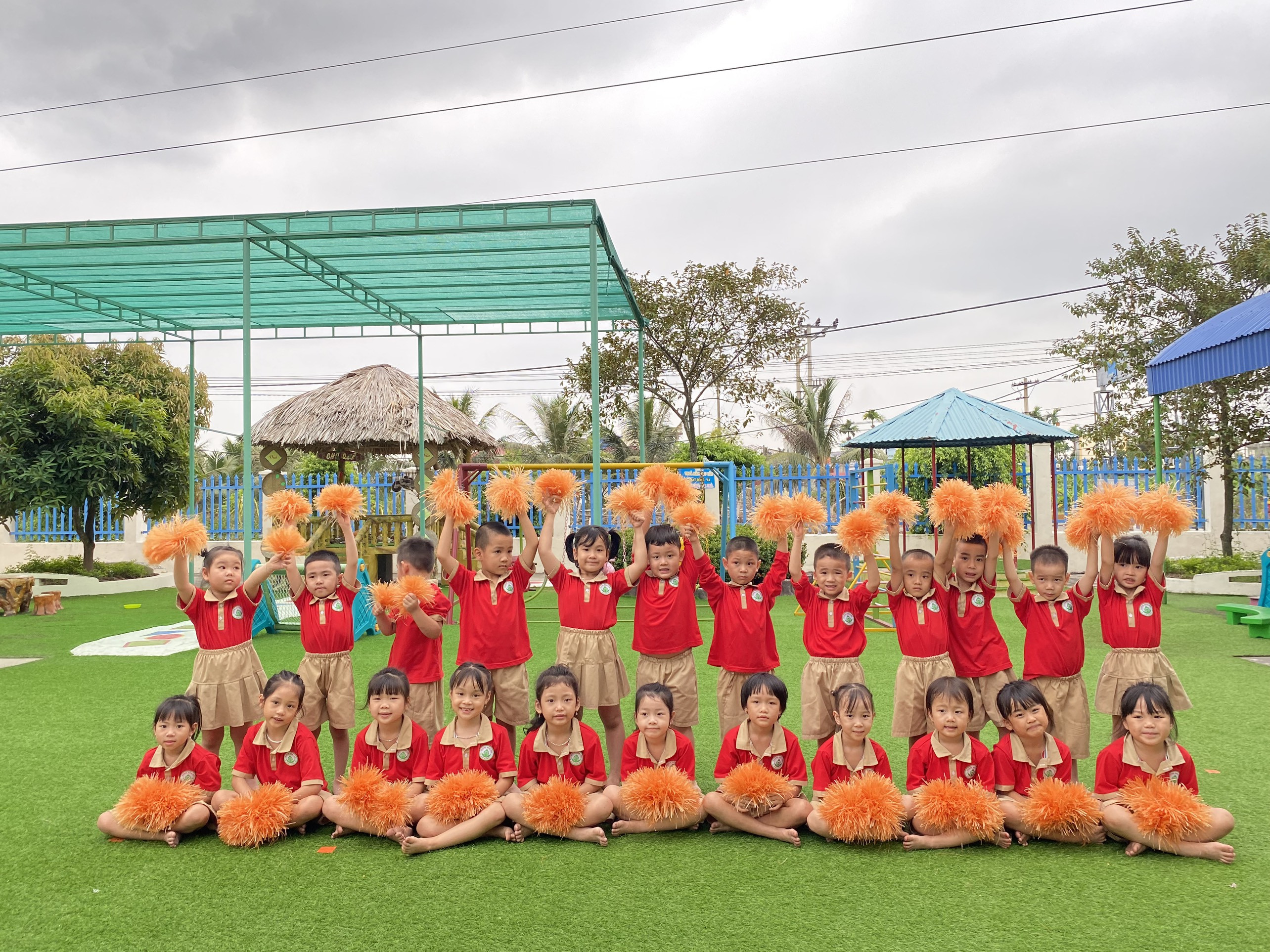 Cô giáo hướng dẫn các em lớp 5A5 tham gia trò chơi vận động chuyền bóng trong sân trường