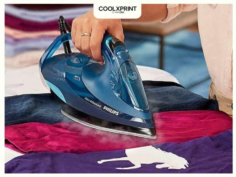 Dùng bàn ủi và khăn ẩm để tách chữ in khỏi bề mặt áo đá bóng
