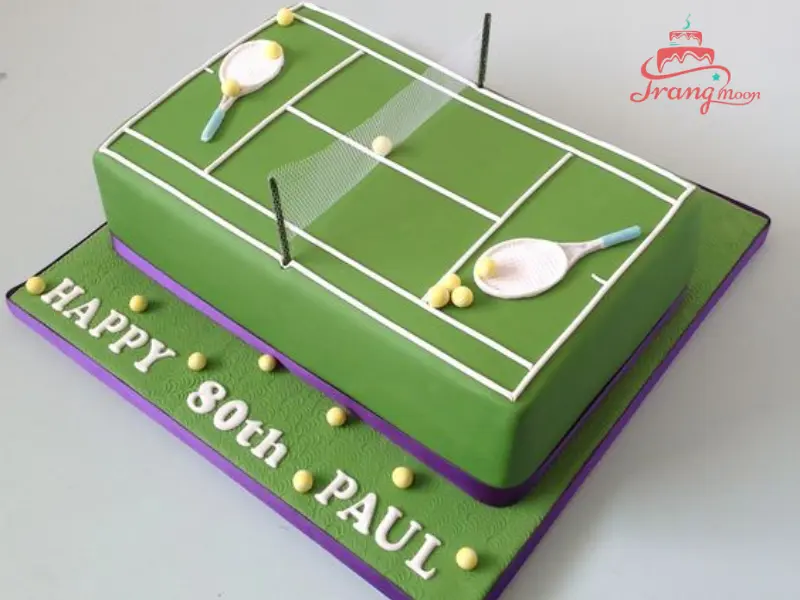 Bánh sinh nhật với trang trí chủ đề tennis, sân đấu và quả bóng, thể hiện niềm đam mê thể thao, tương tự bánh sinh nhật bóng chuyền