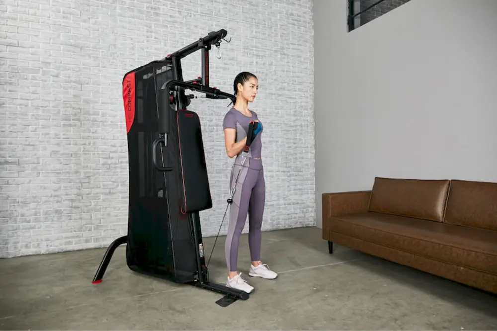 Người phụ nữ tập tạ, thể hiện bài tập sức mạnh trong lịch tập gym cho nữ tăng cơ