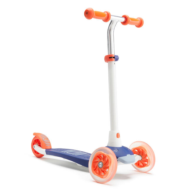 Bé gái vui vẻ lái xe scooter 3 bánh trong công viên