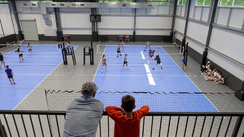 Sân bóng chuyền trong nhà màu tím pastel và xám hiện đại, thiết kế khu vực khán giả chuyên nghiệp