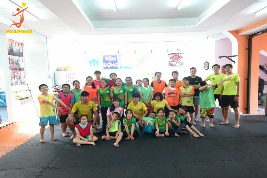 Tập thể đội bóng chuyền ăn mừng chiến thắng, nhấn mạnh vai trò của tinh thần đồng đội trong cách tập bóng chuyền cho người mới chơi