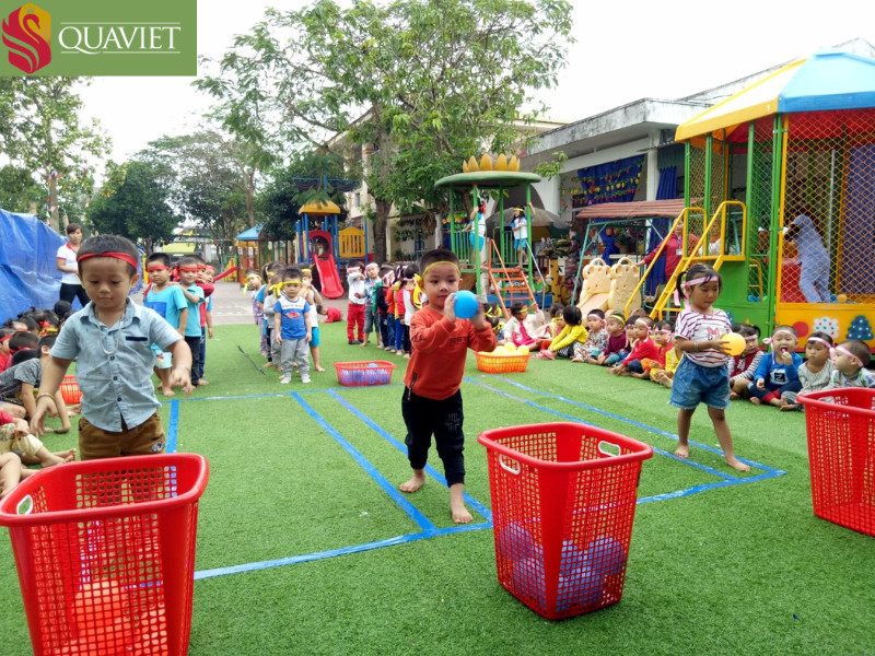 Trẻ em tham gia trò chơi ném bóng vào rổ trong khuôn viên trường học