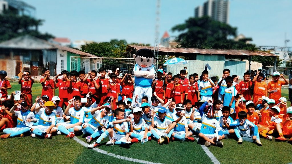 Trẻ em VJSS tập luyện và trao đổi với huấn luyện viên, minh họa môi trường học tập năng động và chuyên nghiệp của trung tâm bóng đá nam việt