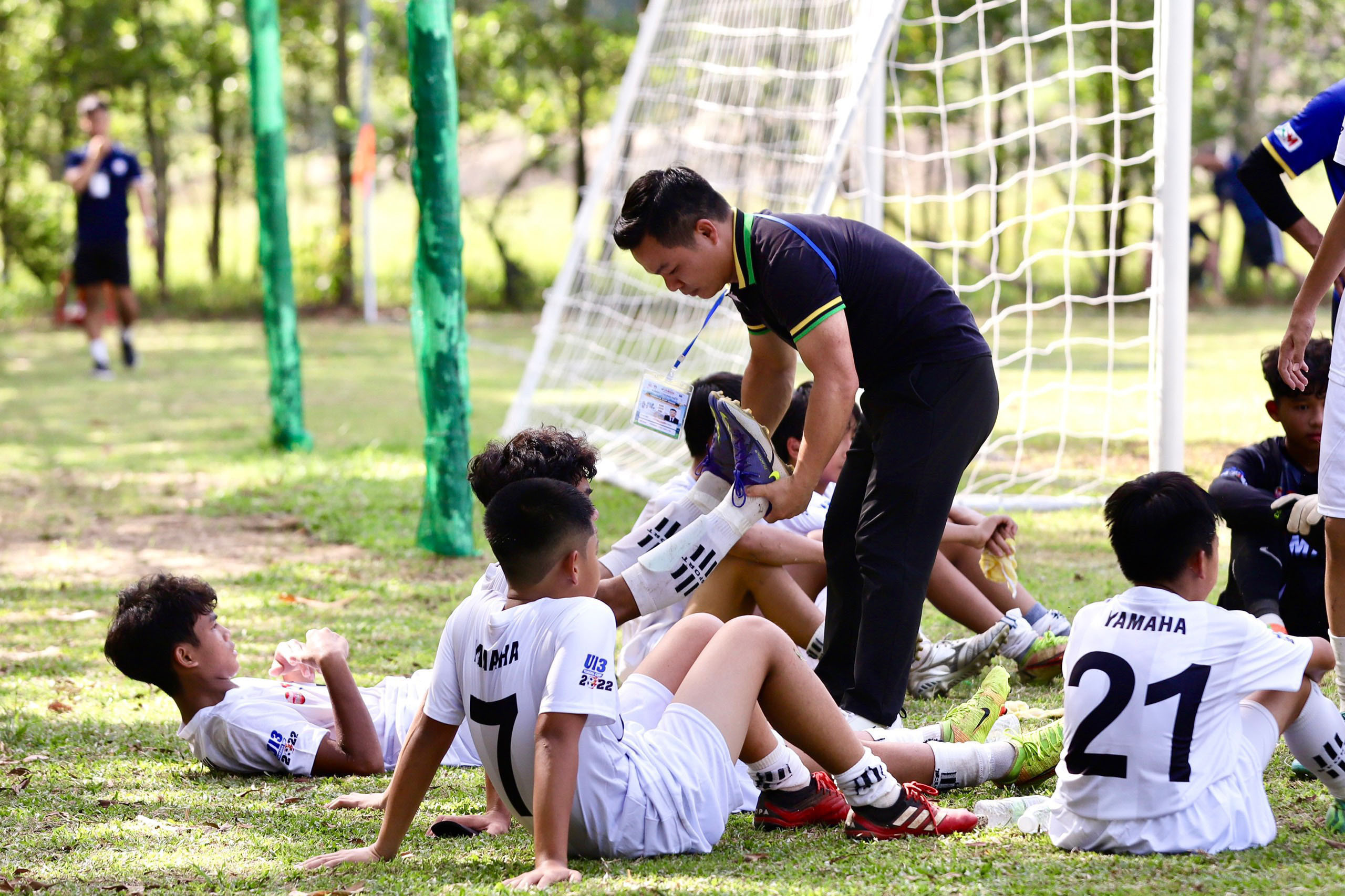 Trưởng đoàn U13 Hoàng Anh Gia Lai Trần Văn Quỳnh cùng các cầu thủ trẻ trong mô hình học viện bóng đá hoàng anh gia lai tuyển sinh