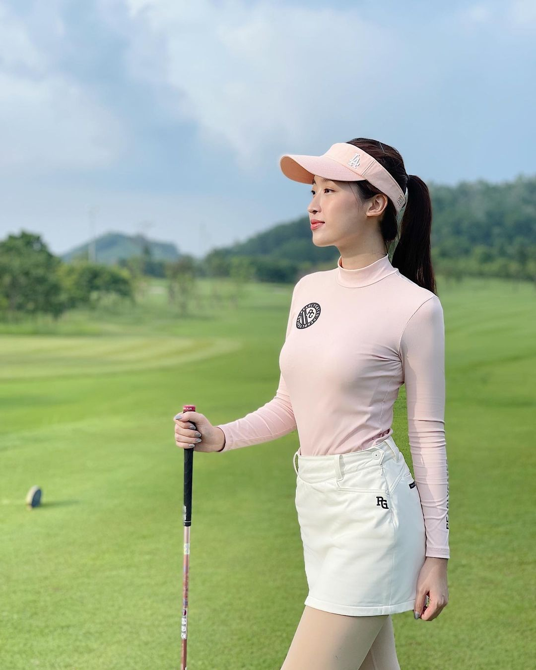 Mẫu trang phục golf nữ: Áo giữ nhiệt mix quần giả váy hồng pastel